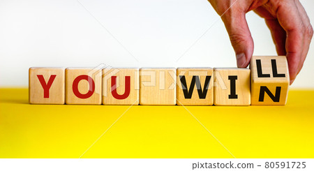 You will win symbol. Businessman turns cubes and changes words you will to you win. Beautiful yellow table, white background, copy space. Business, motivational and you will win concept. 80591725