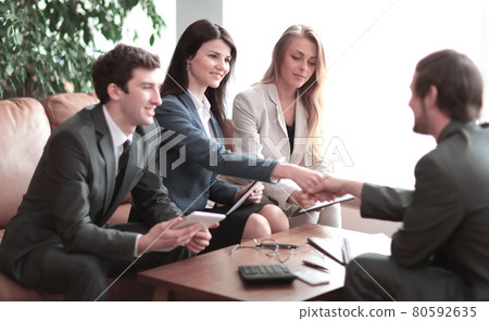 handshake of business partners over a Desk in a modern office. 80592635
