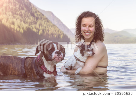 Caucasian Woman swimming in a lake with dog 80595623