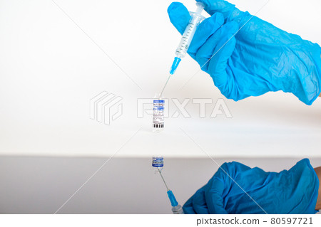 The coronavirus vaccine is in the hands of a doctor, a syringe 80597721