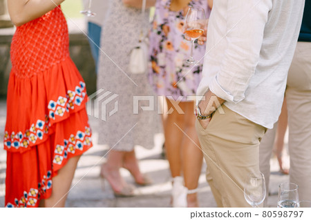 People at the party stand with glasses of various drinks 80598797