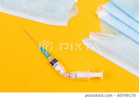 Broken Medical Syringe and Torn Medical Face Mask 80599170