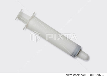 White syringe use with sodium chloride for nasal irrigation. Medical equipment on white laboratory table. White syringe use with sodium chloride for nasal irrigation. Medical equipment on white laboratory table. 80599632