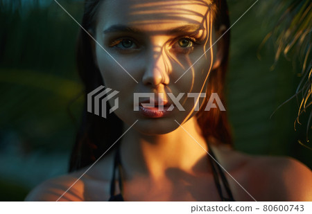 young sexy woman in bikini under palm tree 80600743