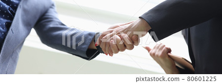 Smiling Businessman and businesswoman shake hands closeup 80601225