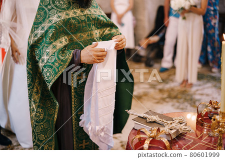 Priest at the wedding holds a white towel Priest at the wedding holds a white towel 80601999