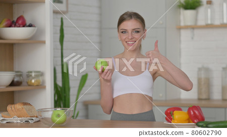 Woman Making Heart Shape by Hands while in Kitchen 80602790