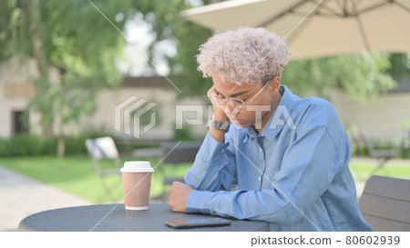 African Woman Taking Nap in Outdoor Cafe 80602939
