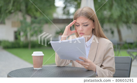 Businesswoman having Loss While Reading Documents  80603291