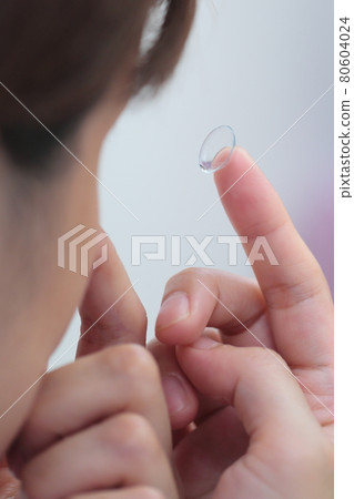 Women wearing contact lenses Women wearing contact lenses 80604024
