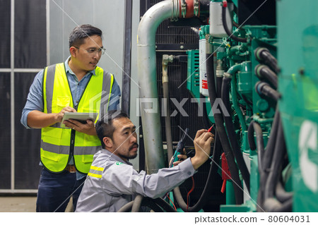 Two technical workers with tablets working in an industry factory's control room plant, checking with technical in a power plant, business and industry concept. 80604031