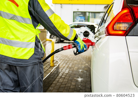 gas station employee in overalls refueling the car gas station employee in overalls refueling the car 80604523