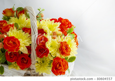 beautiful light wicker basket with yellow and red flowers. holiday, spring, congratulations 80604557