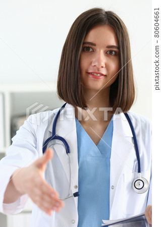 Female medicine doctor hold pad and give arm to shake Female medicine doctor hold pad and give arm to shake 80604661