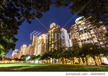 Low angle view of park green space and modern buildings on both sides in downtown Taichung, Taiwan. near the National Taichung Theater. Low angle view of park green space and modern buildings on both sides in downtown Taichung, Taiwan. near the National Taichung Theater. 80604662