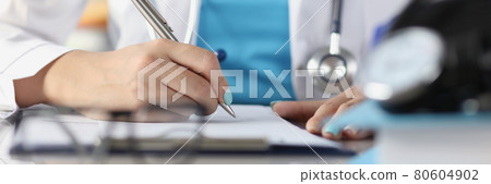 Doctor makes notes on medical records closeup 80604902