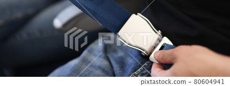 Male hands wearing seat belts on plane closeup Male hands wearing seat belts on plane closeup 80604941