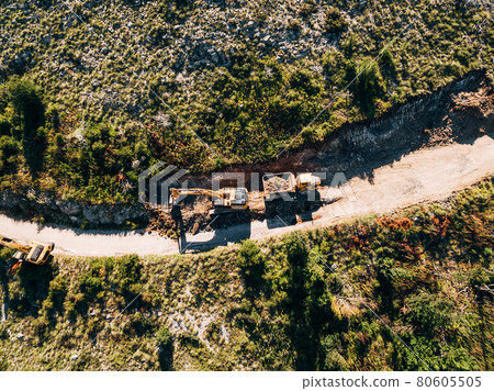 Yellow tracked tractor loads a quarry vehicle with sand. View from above 80605505