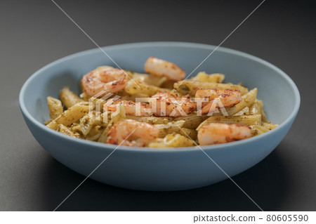 Penne pasta with shrimps and pesto in blue bowl 80605590