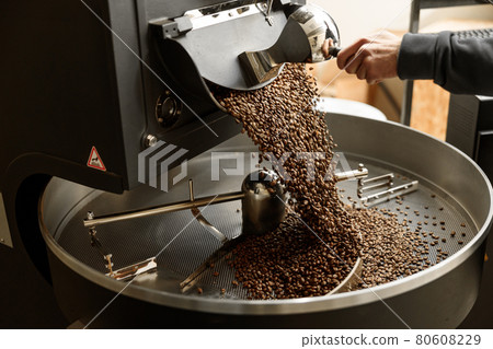 Young specialist worker is roasting coffee in hangar 80608229
