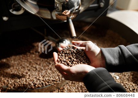 Young specialist worker is roasting coffee in hangar 80608448