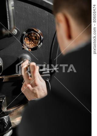 Young specialist worker is roasting coffee in hangar 80608474