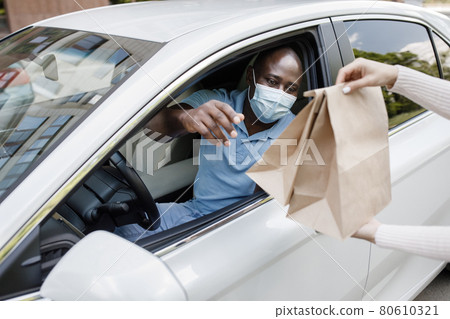 Black guy driver in face mask taking take away food 80610321