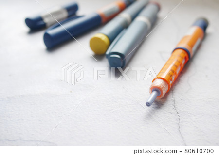 Insulin pens on wooden background, close up  80610700