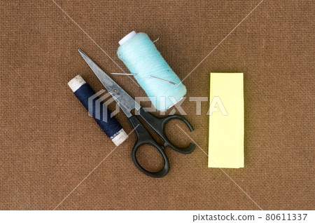 Group of sewing tools and items for knitting and weaving placed on a brown colour woven paper board. DIY Art and craft background concept. Group of sewing tools and items for knitting and weaving placed on a brown colour woven paper board. DIY Art and craft background concept. 80611337