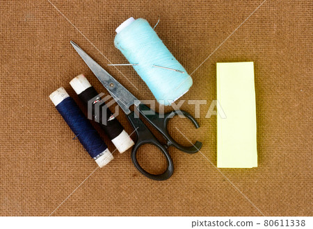 Group of sewing tools and items for knitting and weaving placed on a brown colour woven paper board. DIY Art and craft background concept. Group of sewing tools and items for knitting and weaving placed on a brown colour woven paper board. DIY Art and craft background concept. 80611338