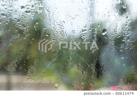 Rain drops on glass window. Raindrops falling from glass material. Abstract nature background. Copy space for text. Focus on foreground. Rain drops on glass window. Raindrops falling from glass material. Abstract nature background. Copy space for text. Focus on foreground. 80611474