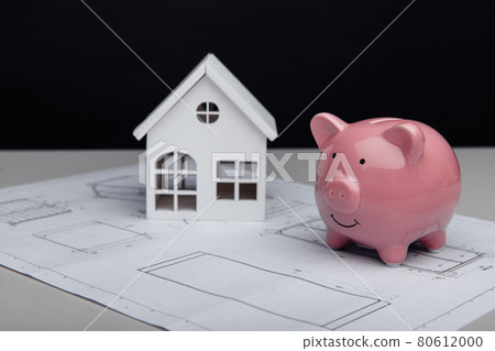 White house and piggy bank with architectural plan. House building costs White house and piggy bank with architectural plan. House building costs 80612000