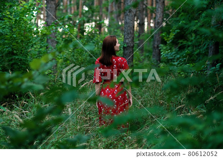 Save and Plant Trees, Save Earth and Nature, Stand For Trees, Save Forests and Heal the Climate. Woman in a red dress walking in forest, hugging trees and touching the trunks 80612052