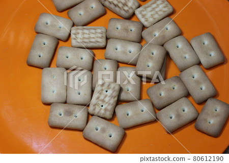 Many rectangular biscuits with small pores in red plate 80612190