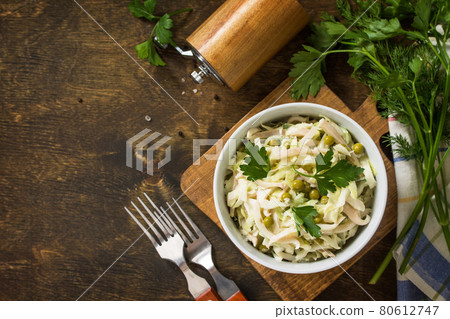 Salad with fresh cabbage, calamary, cucumber and green peas in a bowl on a rustic table. Top view flat lay background. Copy space. Salad with fresh cabbage, calamary, cucumber and green peas in a bowl on a rustic table. Top view flat lay background. Copy space. 80612747