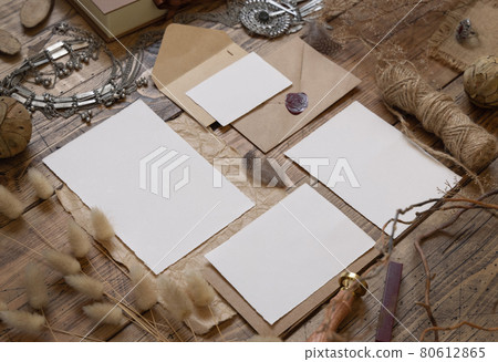 Wedding blank cards laying on a wooden table with bohemian decoration around 80612865