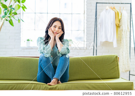 坐在客廳沙發上的年輕女人 80612955