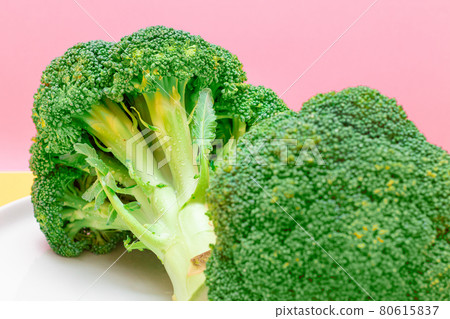 Two Fresh and Raw Pieces of Broccoli on White Plate. Uncooked Green Cabbage Two Fresh and Raw Pieces of Broccoli on White Plate. Uncooked Green Cabbage 80615837