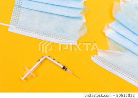 Broken Medical Syringe and Torn Medical Face Mask 80615838
