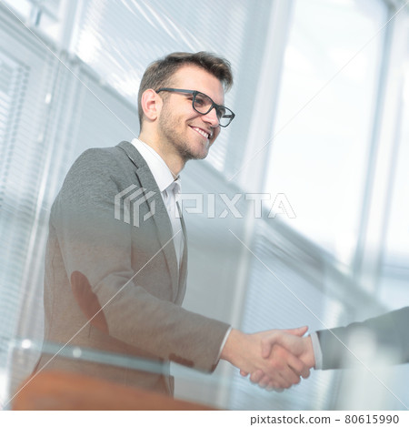 close up.modern young man shaking hand with the Manager. 80615990