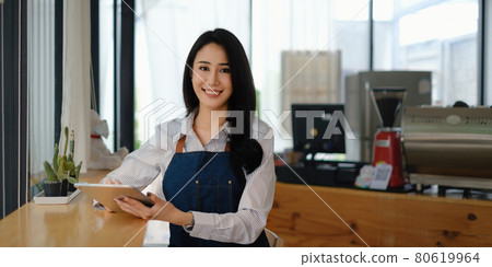 At her cafe, the business owner or barista is taking orders from customers 80619964