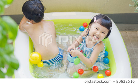 Kids playing in a vinyl pool Kids playing in a vinyl pool 80622516