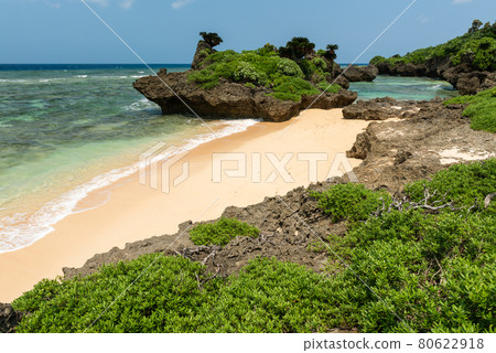 Rocks view of a tropical beach, coastal rocks, smooth sands, emerald green sea, blue sky, paradise concept. Iriomote Island. 80622918