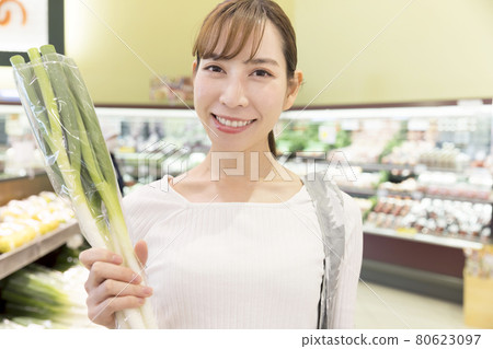 Shopping image of a young woman showing a supermarket onion Shopping image of a young woman showing a supermarket onion 80623097