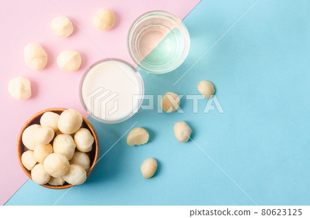 Macadamia milk in a glass and a bowl of macadamia nuts with oil. Macadamia milk in a glass and a bowl of macadamia nuts with oil. 80623125