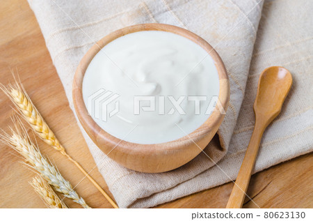 Greek yogurt in a wooden bowl and dry barley. Greek yogurt in a wooden bowl and dry barley. 80623130