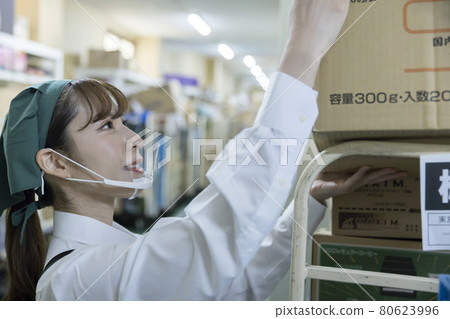 A female employee working with a mouse shield in the backyard of a supermarket 80623996