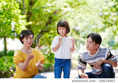 Young family playing with soap bubbles Young family playing with soap bubbles 80624061