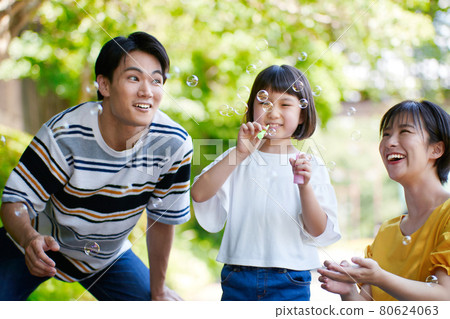 Young family playing with soap bubbles 80624063