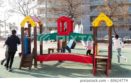 Smiling kids playing together on playground outdoors 80624774